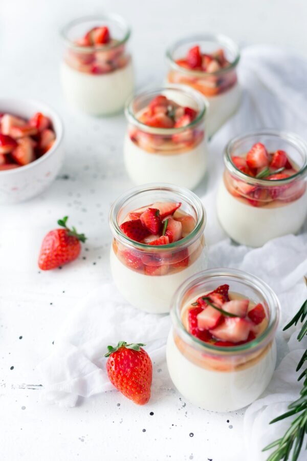 sliced strawberries in clear sliced strawberries in clear glass jar with cream