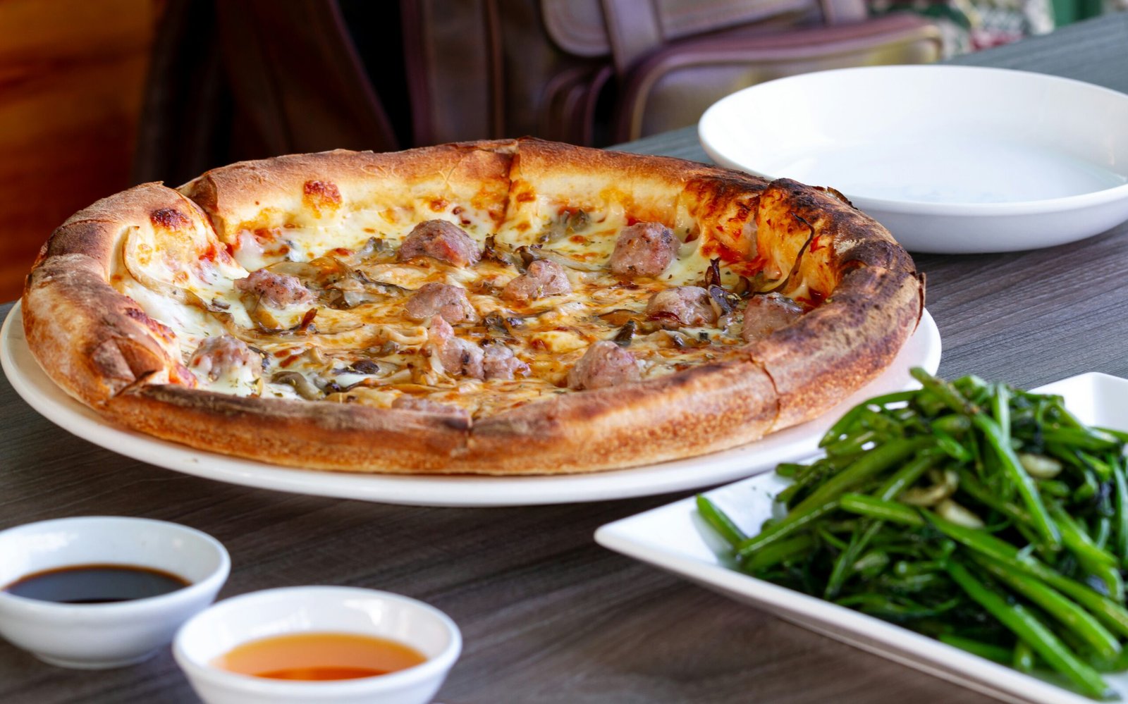 A pizza sitting on top of a white plate on top of a wooden table