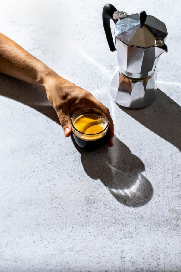 person holding clear glass person holding clear glass mug with brown liquid