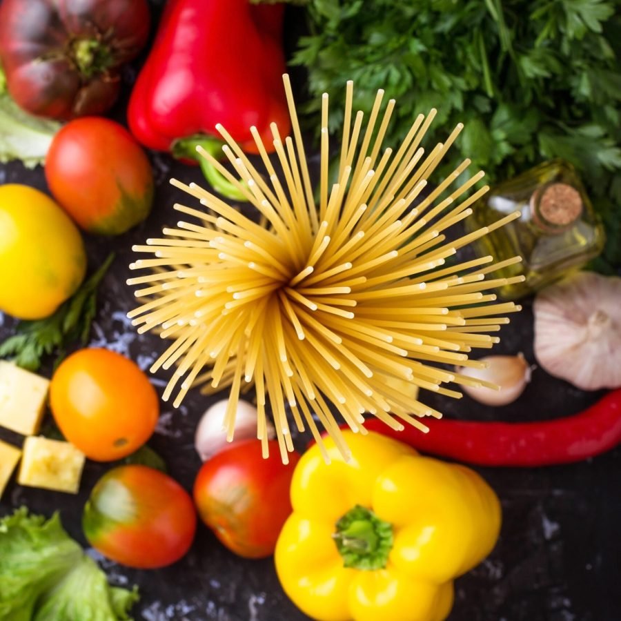 Concept of Italian food. Pasta, tomato, olive oil, pepper, parsley and cheese. Selective focus. Top view