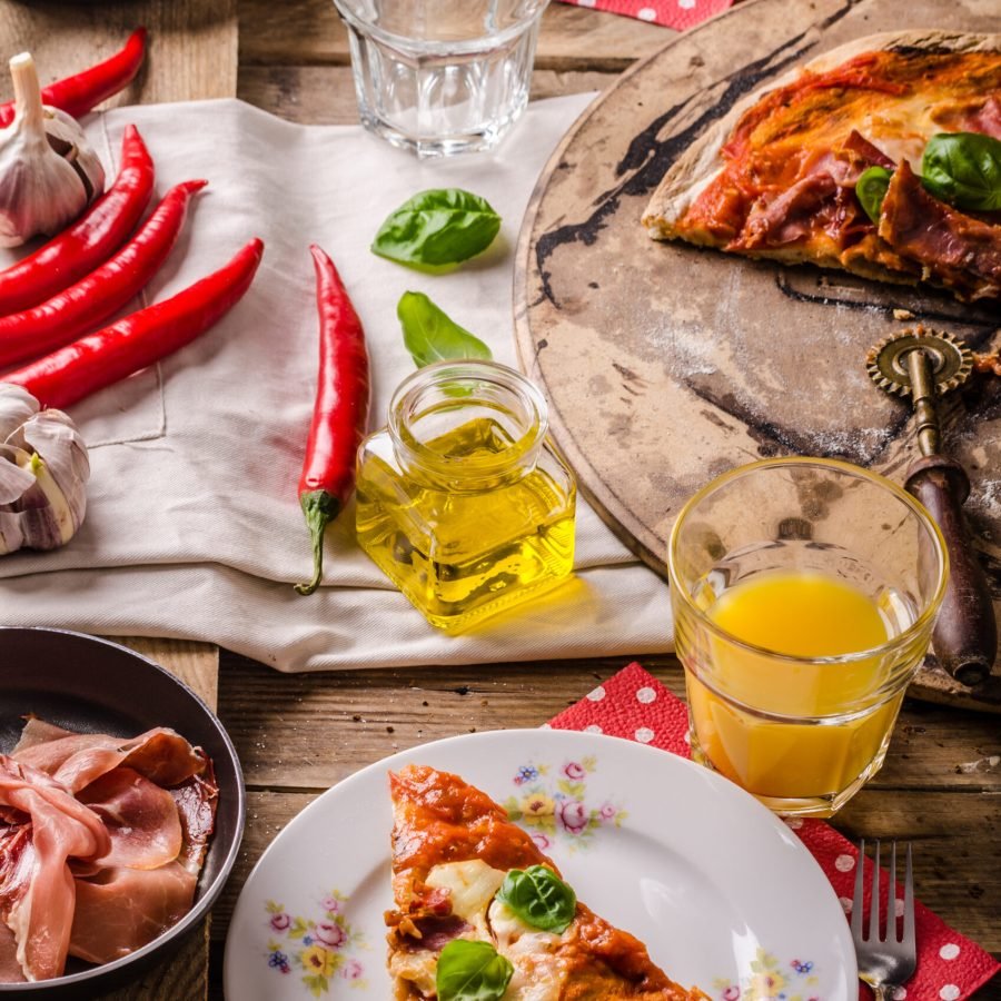 Rustic Italian pizza margherita with prosciutto and basil